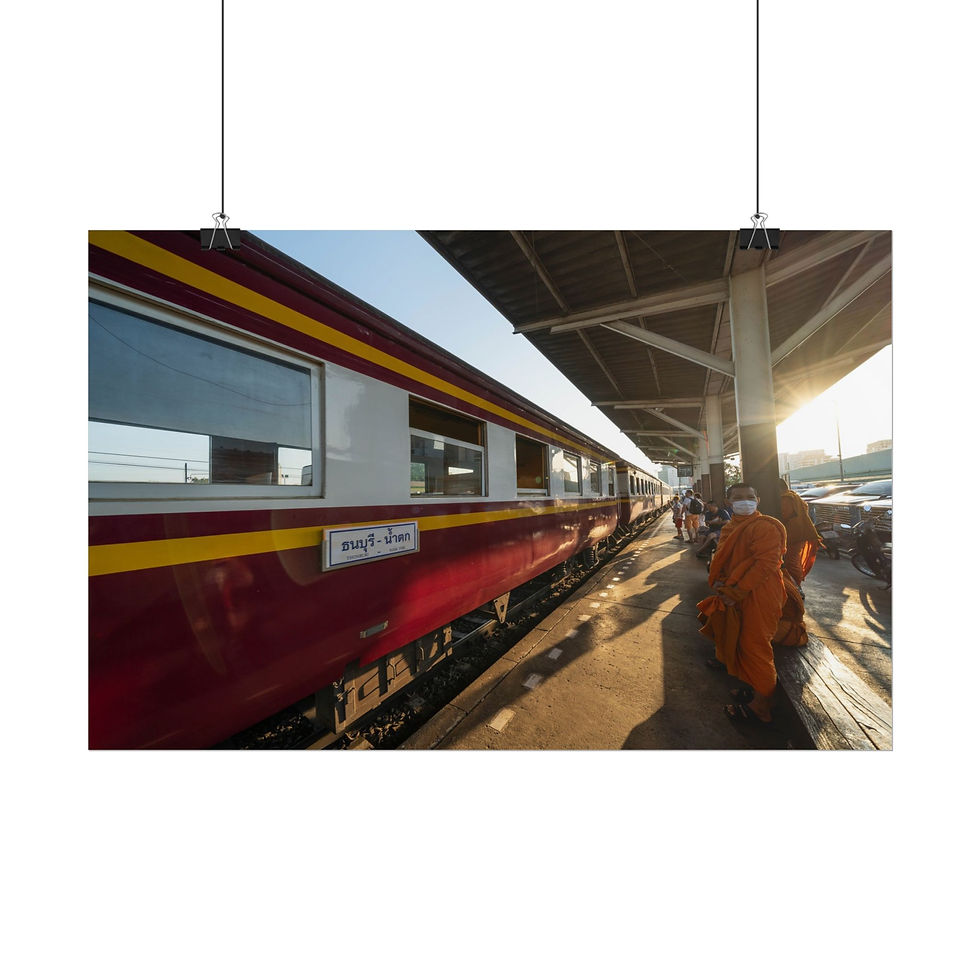 Thumbnail: Orange robed monks wait beside a train at a sunny railway station.