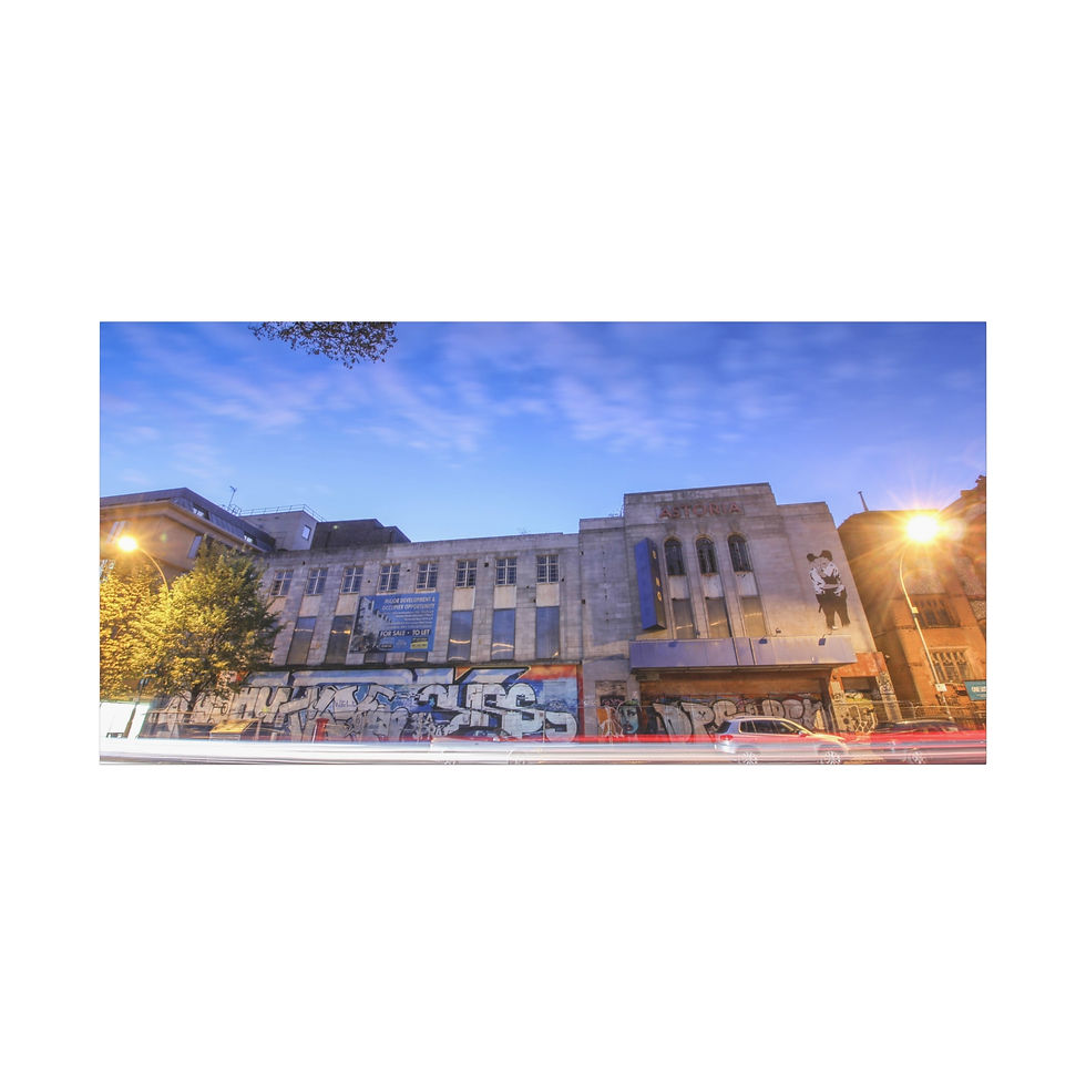 Thumbnail: Building with graffiti "SKULLS" on lower facade, under blue sky.