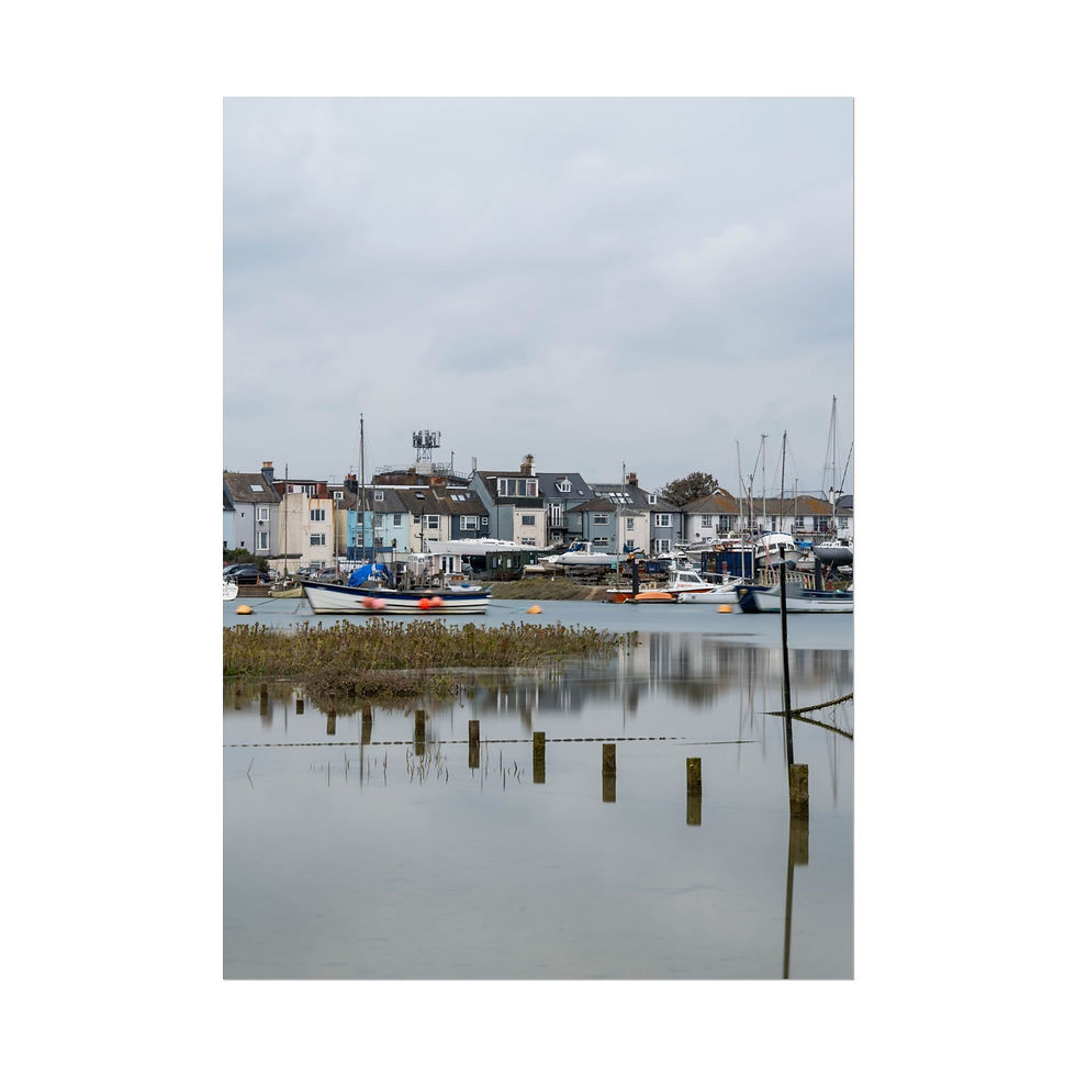 Thumbnail: Overcast harbor with waterfront buildings, boats, and wooden posts in water.