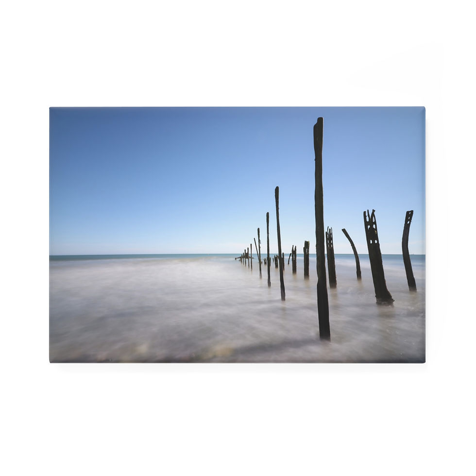Thumbnail: Old wooden pilings stand in misty water under a clear blue sky.