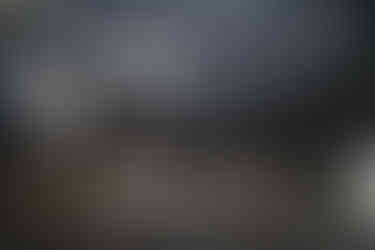 Aragats Scientific Center - Orgov Radio-Optical Telescope. Charred, wide interior of a large, abandoned building, with soot-blackened walls and ceiling. Sunlight filters through broken windows, casting shadows.