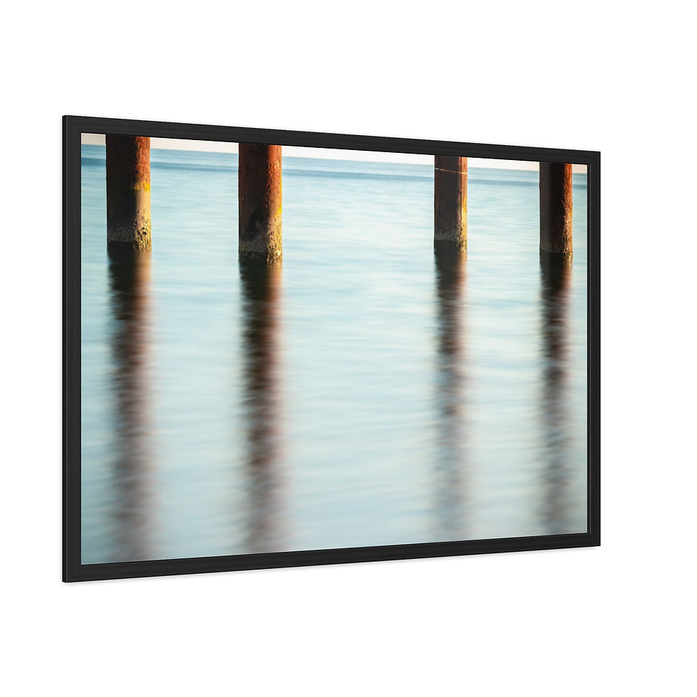 Thumbnail: Framed picture of weathered pier pilings reflected in calm blue water.