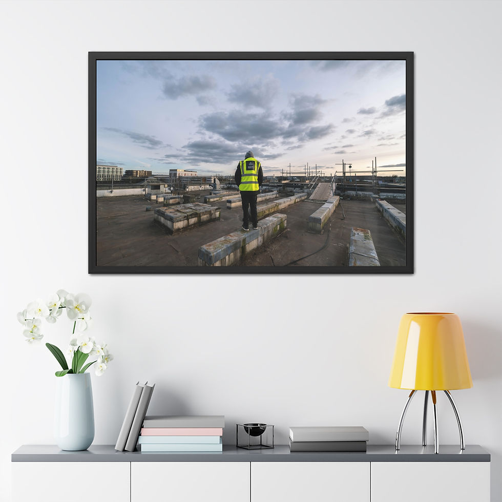 Person in hi-vis vest on concrete blocks, cloudy urban rooftop.