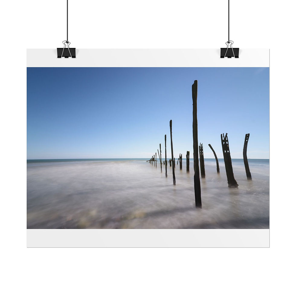 Thumbnail: Old wooden pilings stand in misty water under a clear blue sky.