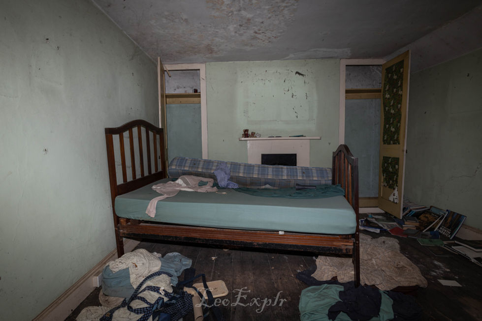 Abandoned bedroom with blue bed sheets.