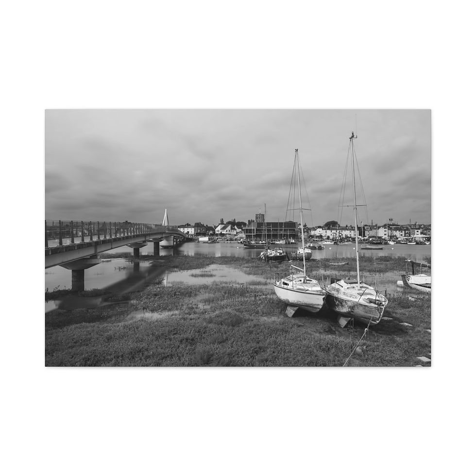 Thumbnail: Black and white grounded sailboats, long bridge, and distant town.