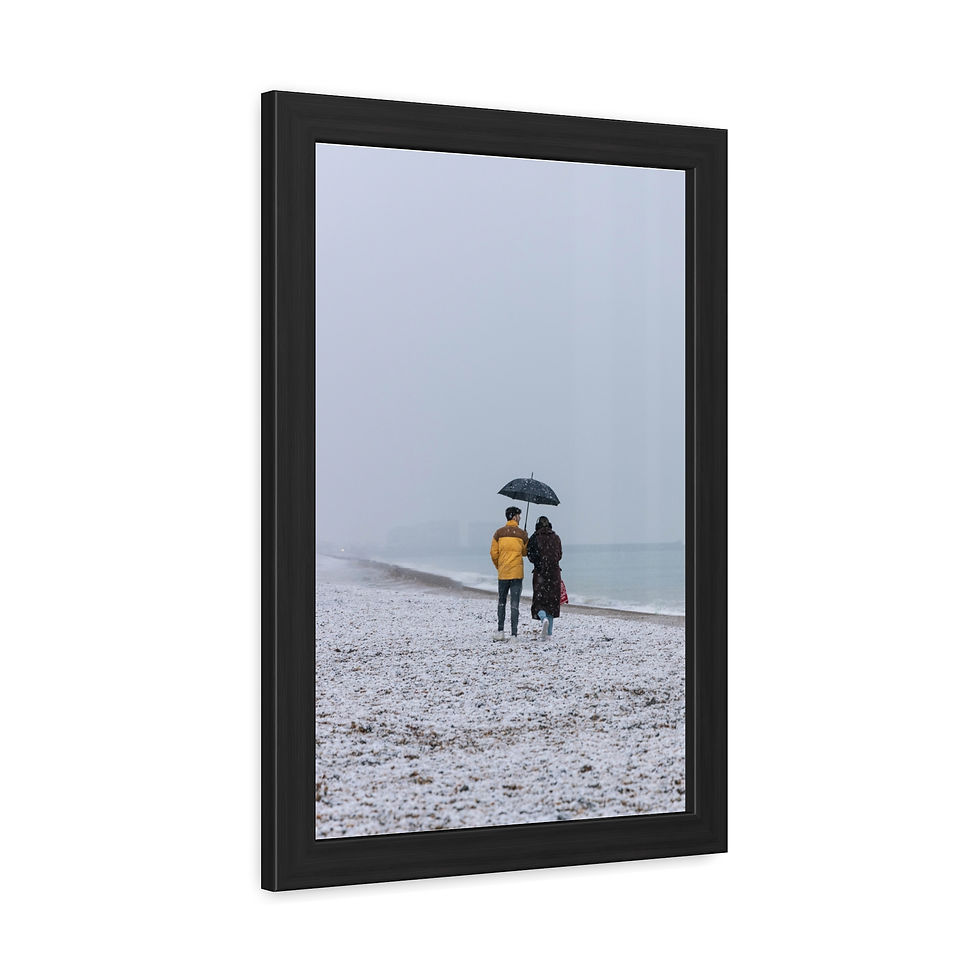 Thumbnail: Two people under umbrella walk on snowy beach near a cold ocean.
