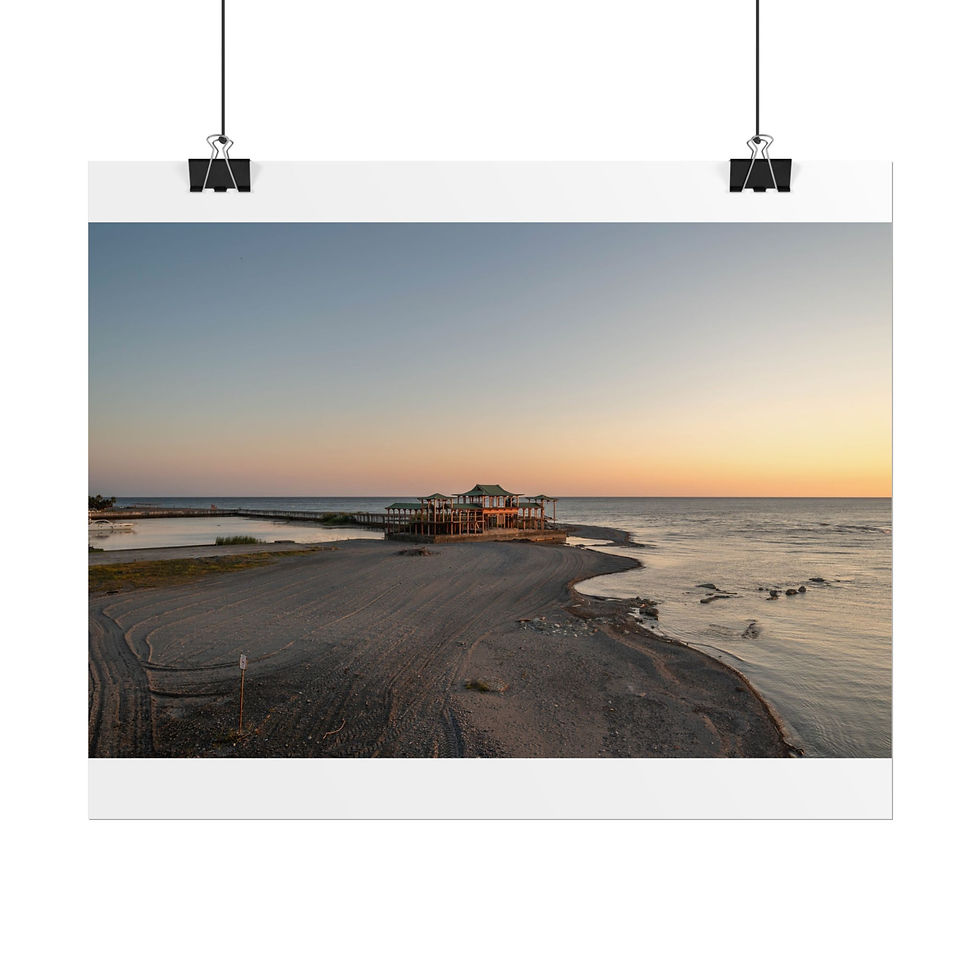 Thumbnail: Sunset over a wide sandy beach with a building near the ocean.
