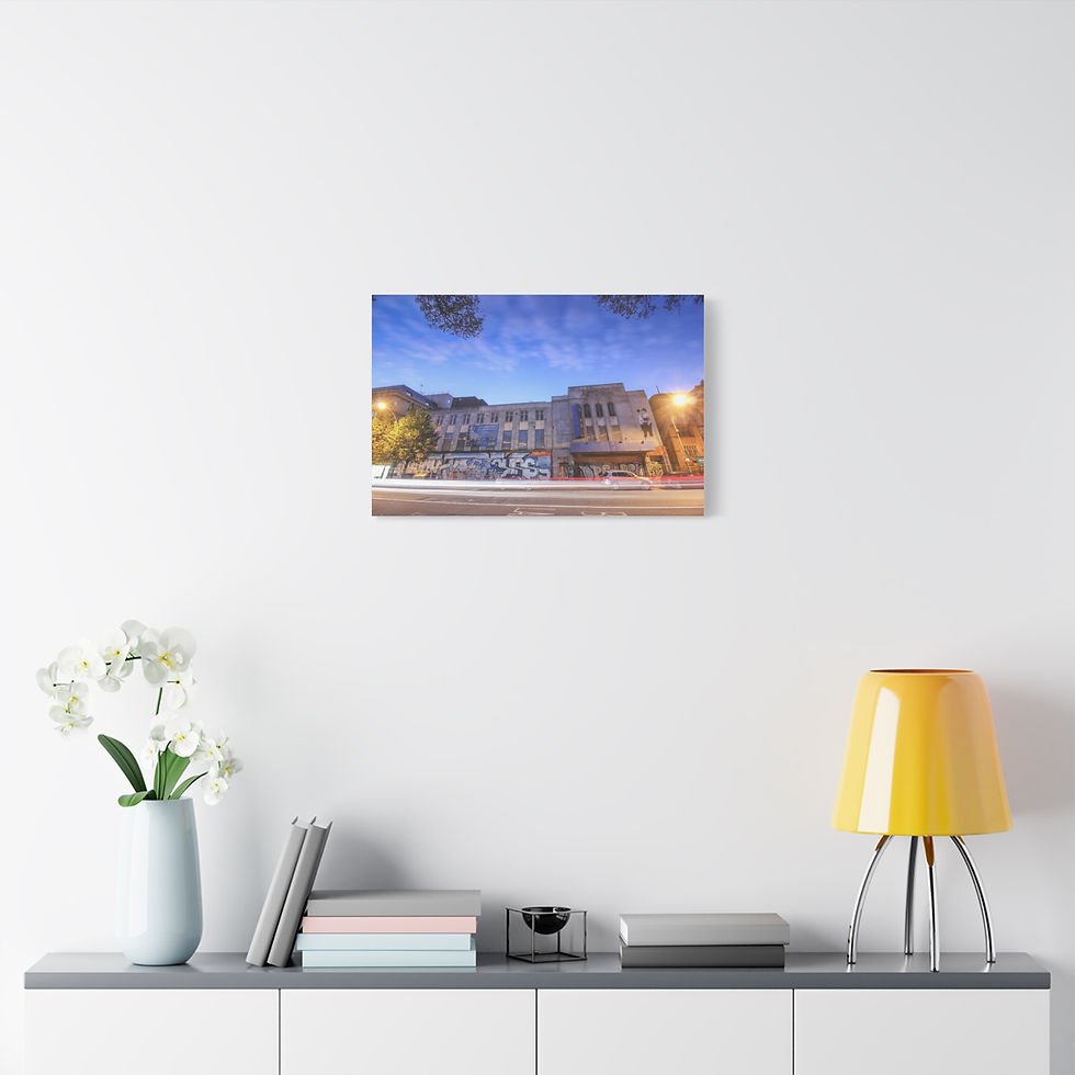 Thumbnail: Canvas print: illuminated city streetscape with buildings under a blue night sky.