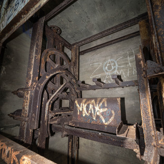 Grain Tower in Isle of Grain - Rusted remains of old machinery in an abandoned building with graffiti.