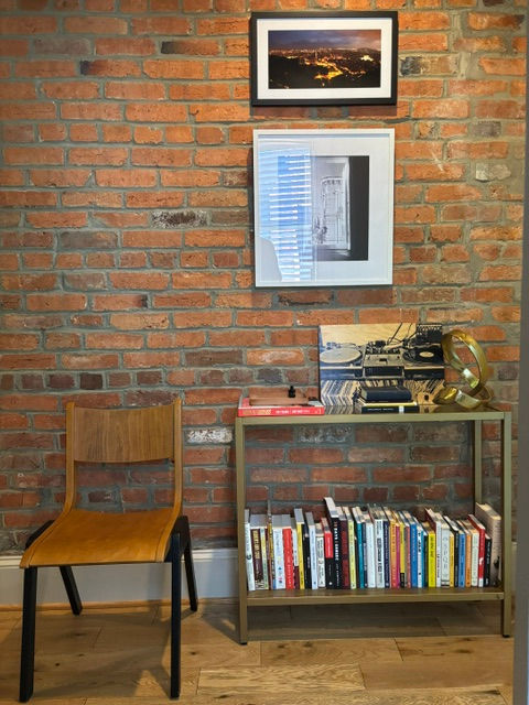 Exposed brick reading nook with vintage bar cart and curated library