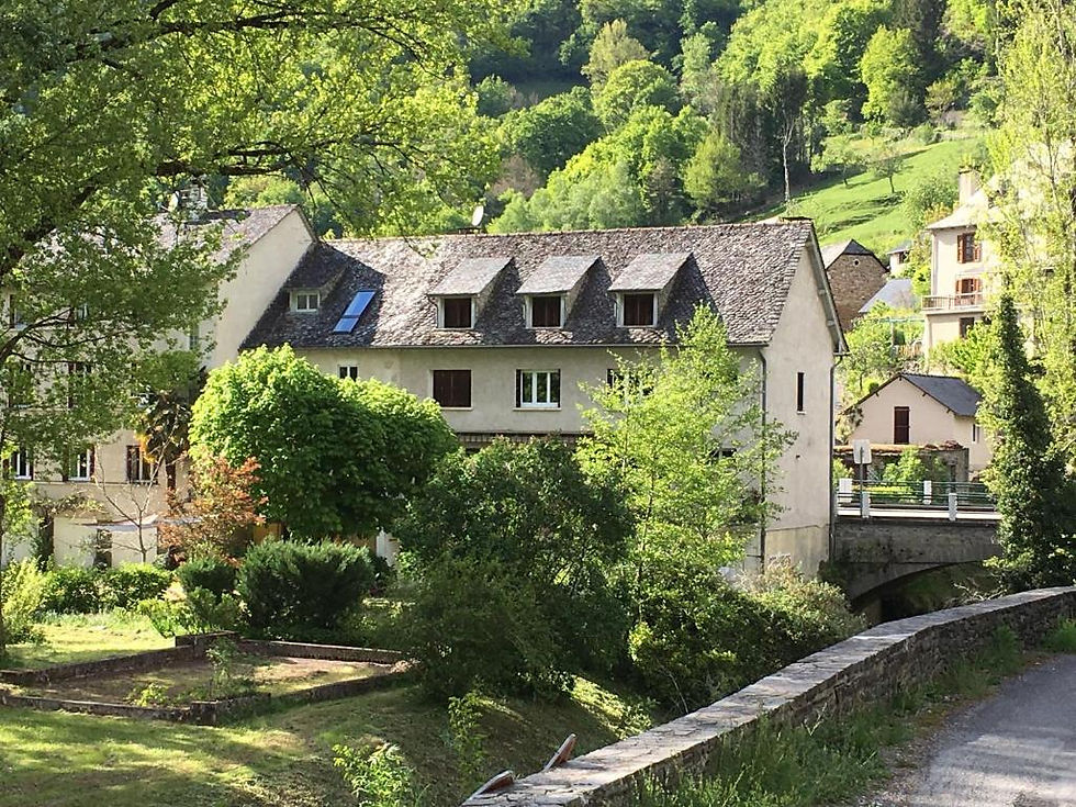 Traditional stone house with dormer windows in a lush valley