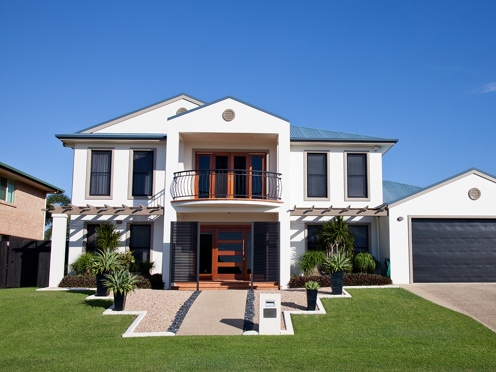 Modern two-story house with white walls, blue roof, and balcony. Neat green lawn and paved path lead to the entrance. Bright, clear sky.