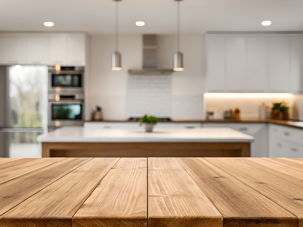 Wooden countertop with a blurred modern kitchen in the background. White cabinets, stainless appliances, and pendant lights create a cozy feel.