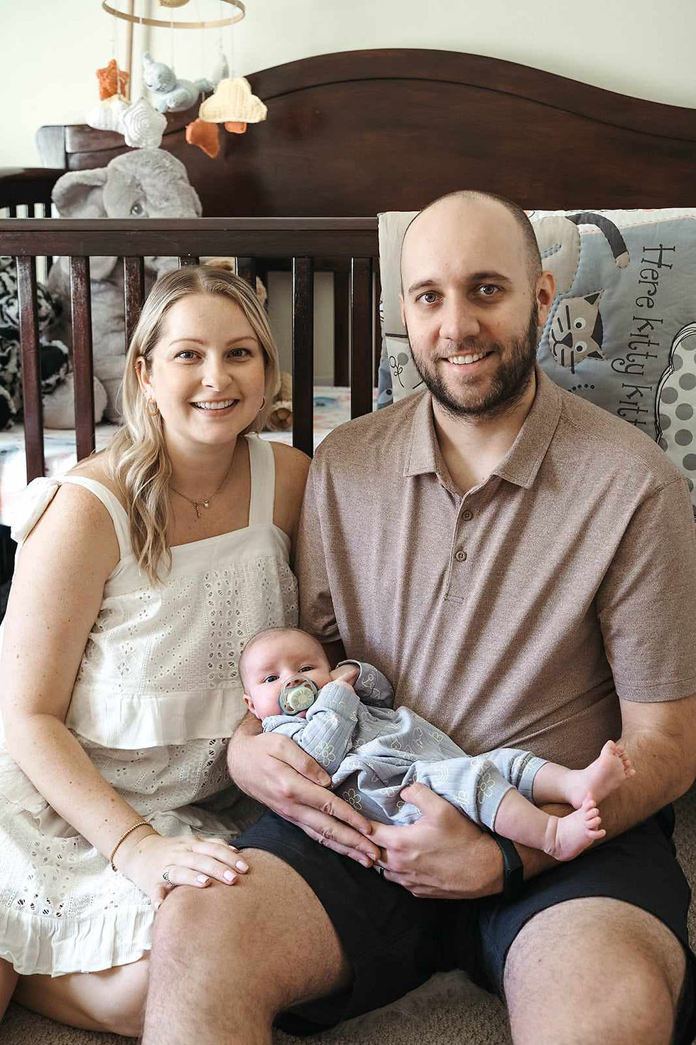 A photo of Connor sitting with his family in his daughter's room.