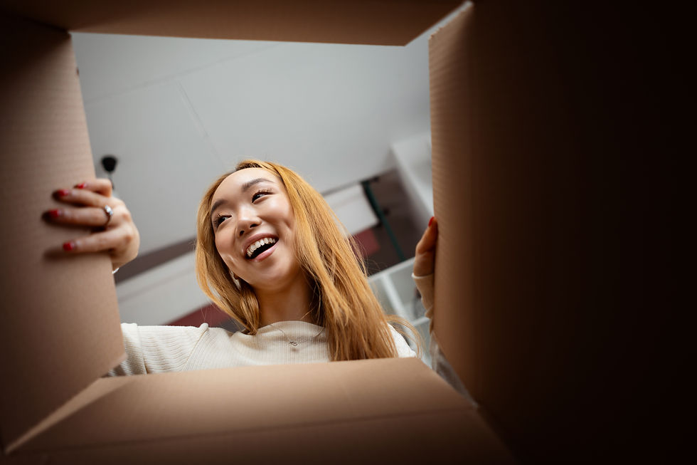 happy-young-woman-excitedly-looks-into-cardboard-b-2025-03-07-13-53-20-utc.jpg