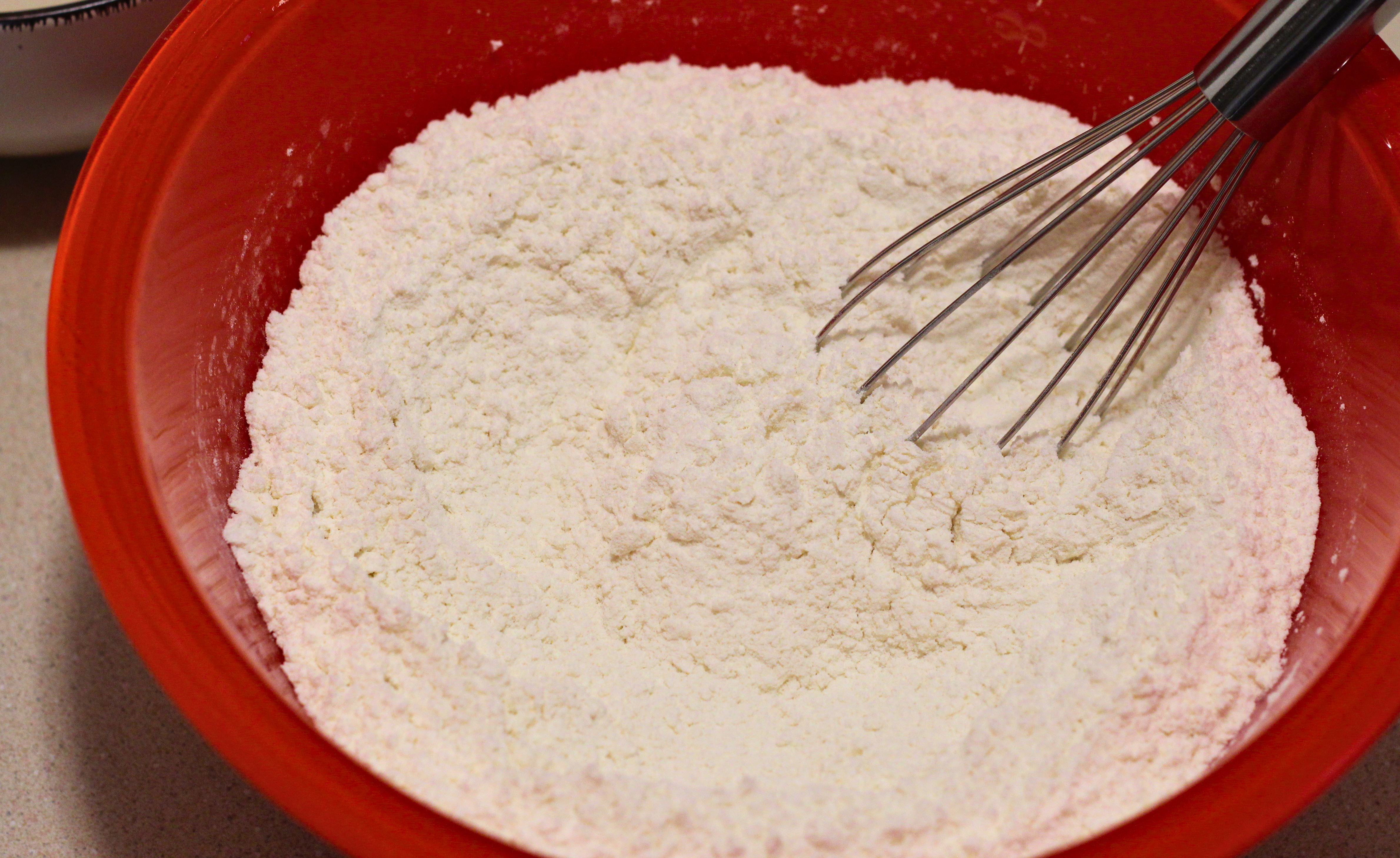 Flour, baking soda, and salt in a red bowl.