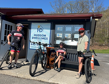 group of cyclists in front of real estate office