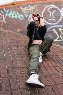 Woman in cargo pants and crop top on bricks with graffiti