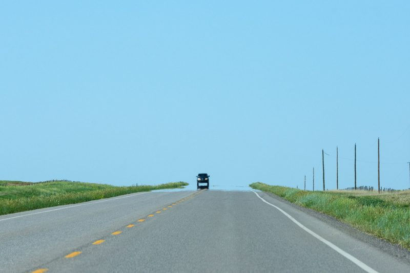 A mirage of a water on the road as a car drive on top
