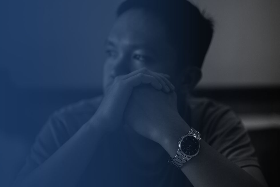 Worried man with his hands clasped in front of his face