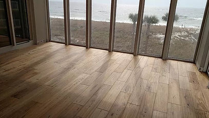 Professional installer applying glue-down hardwood planks