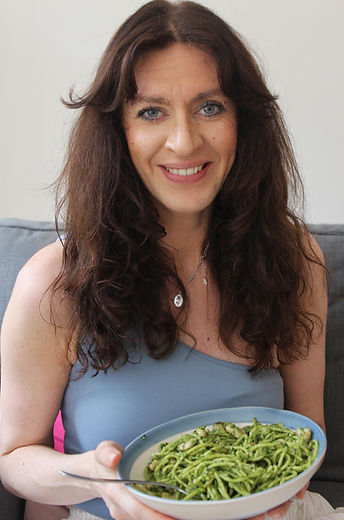 Balanced Imogen smiling while holding a nourishing wholefood meal that supports flexible healthy eating.