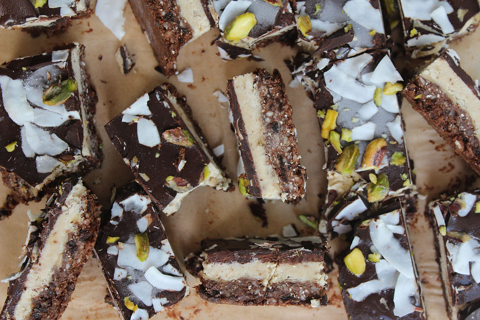 Overhead view of sliced Triple Layer Brownie Bliss Bars topped with coconut and pistachio.