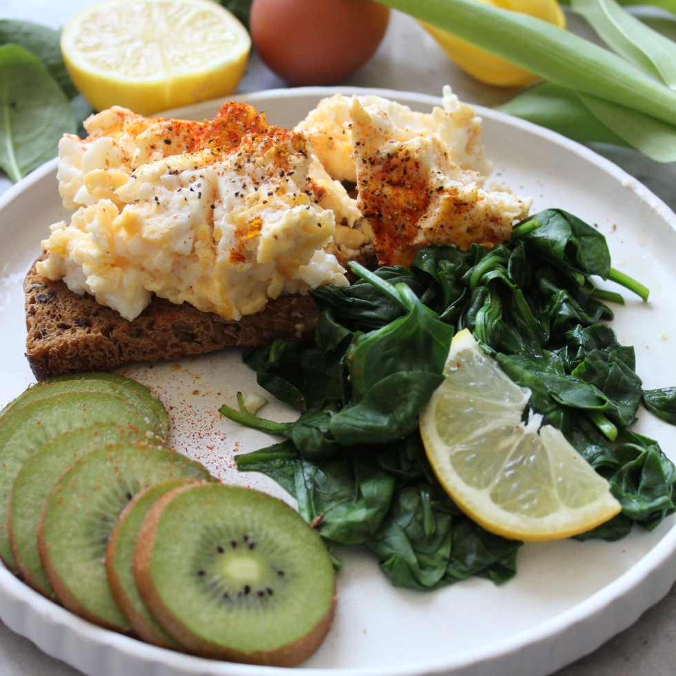 Turmeric eggs on spinach with lemon and kiwi, a simple iron-supportive breakfast for energy and hormone health