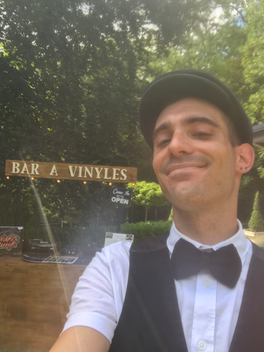 Maxime souriant devant l'enseigne Bar à vinyles