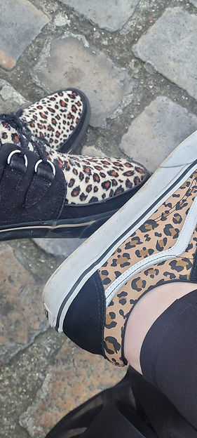 Deux paires de chaussures à motif léopard sur un sol pavé