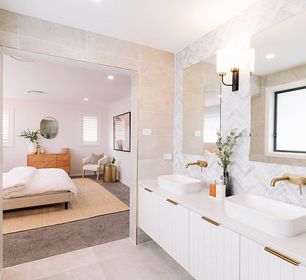 Elegant bathroom with dual sinks and a view into the bedroom