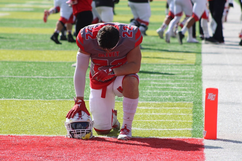 OLIVET, MICHIGAN (October 15, 2022)- Olivet sophomore Blake Hawkins kneels before the start of the Comets’ game against Trine University.