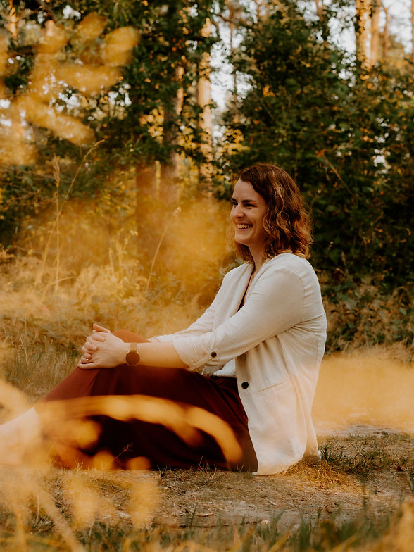 Dr.Stefanie Barkallah sitzend im Wald