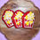 Thumbnail: close up of 3 popcorn dog cookies with puffed rice. red and yellow. on a wooden plate