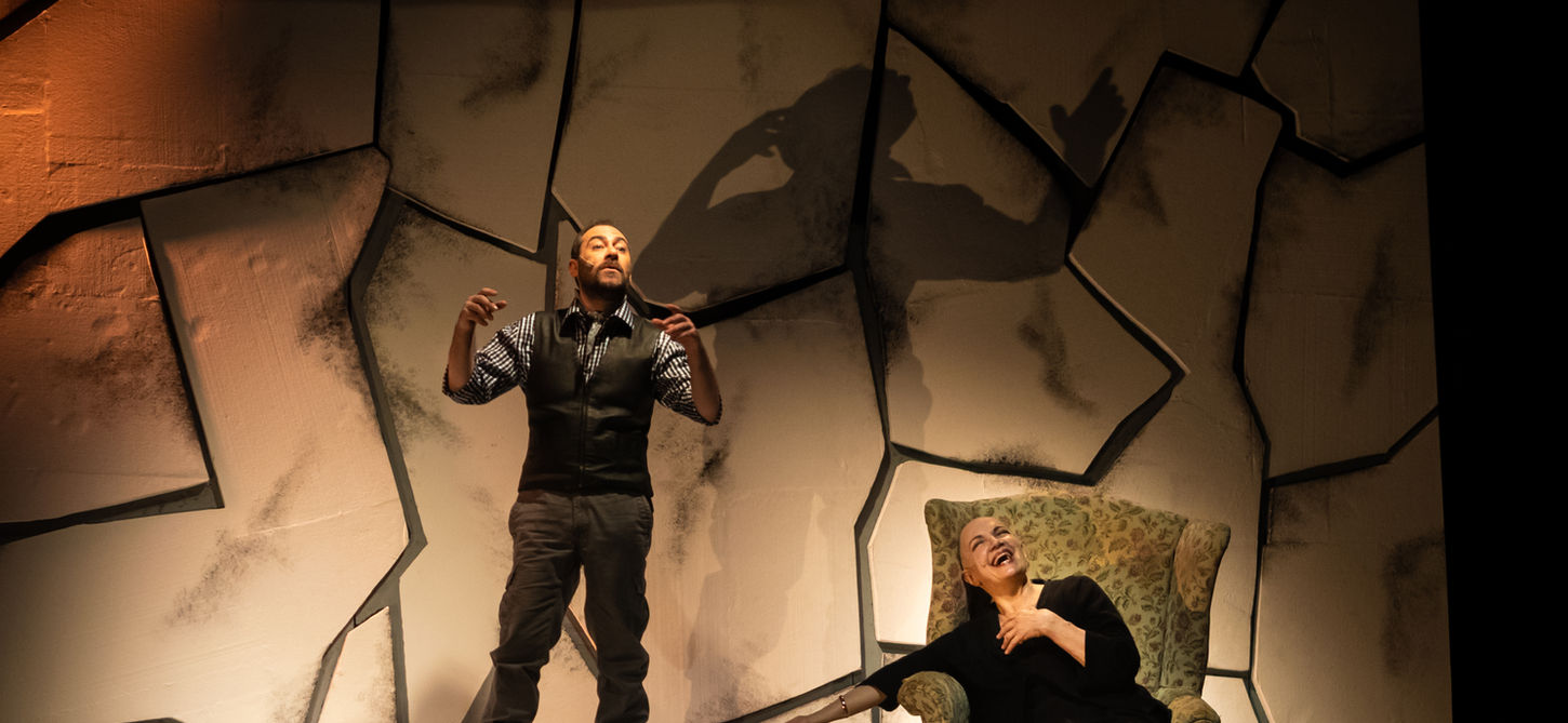 Nella foto sono presenti tre personaggi. In piedi Mario Incudine ha le braccia piegate e un po' alzate. Una donna è seduta su una poltrona mentre ride. Un uomo è seduto per terra e appoggia la testa alle gambe di lei. Lo sfondo è un muor bianco con sagome irregolari. Lo spettacolo andrà in scena al Teatro Bobbio de La Contrada Teatro Stabile di Trieste