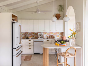 A bold colorful kitchen with white cabinets and terrazzo floors