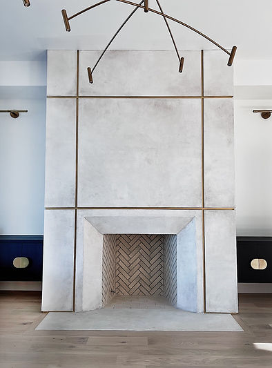 Custom plaster fireplace with a subtle textured finish in neutral tones, accented by gold bar detailing for a modern and elegant design.