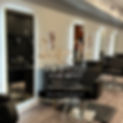 Interior of DazjaVu Styling Studio in Chicago with salon booths available for rent, featuring modern black chairs and booth rental sign with included services