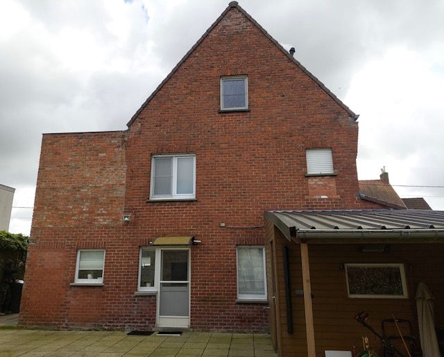 Achtergevel van woning in Torhout vóór gevelrenovatie met spuitkurk