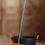 Thumbnail: An orange shavings fork with a silver handle, leaning against a black muck bucket with pink handles.