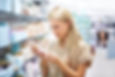 young woman reads the information on a bottle of lotion