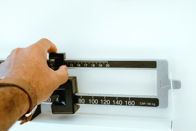 Image photo of person hand on weight scale