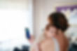 Newborn baby on mother shoulder. Mother using mobile phone.