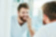 shot of a young man looking at his teeth in the bathroom mirror