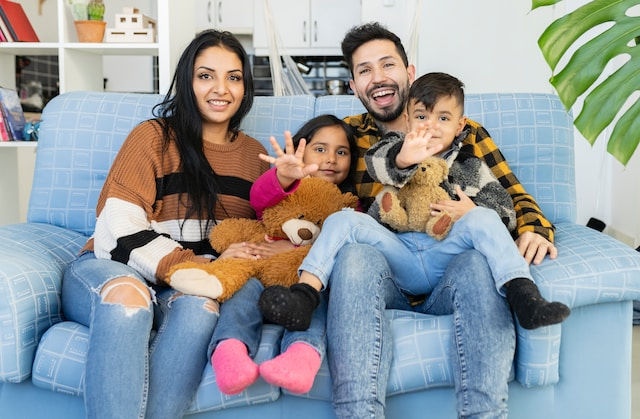 portrait of happy father and mother with their children inside the house