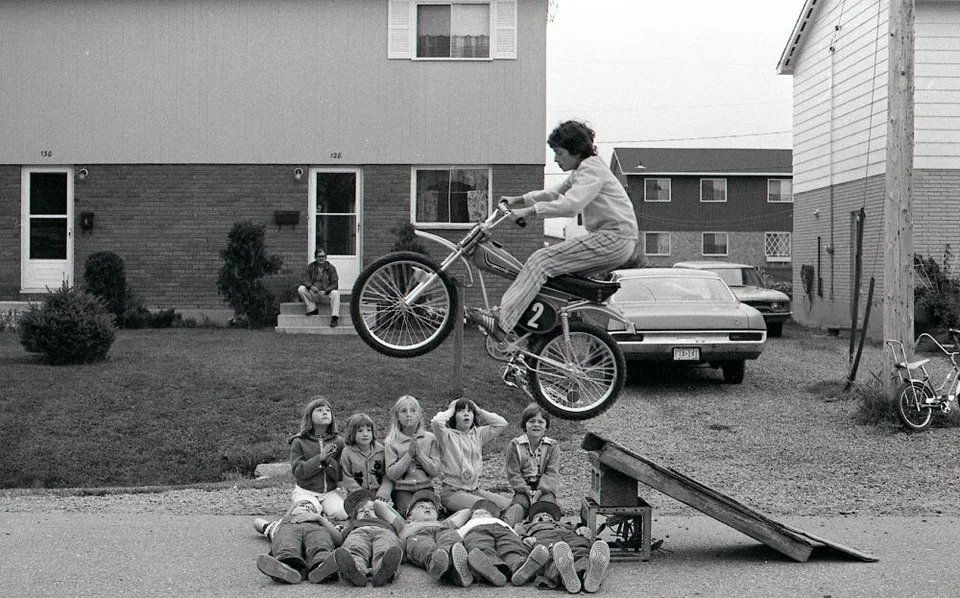 A boy riding his bicycle doing stunts