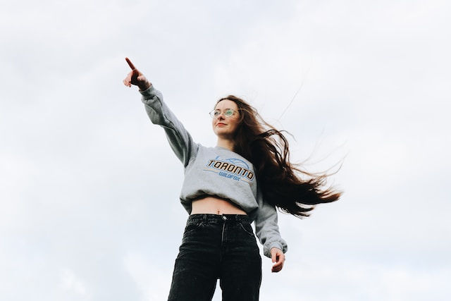 a woman with glasses pointing to something