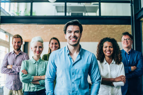 Shot of confident smiling businessman standing in front of his successful team.