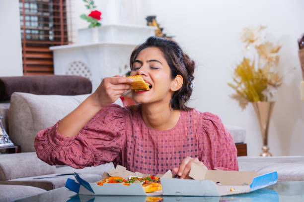 Woman eating pizza at home